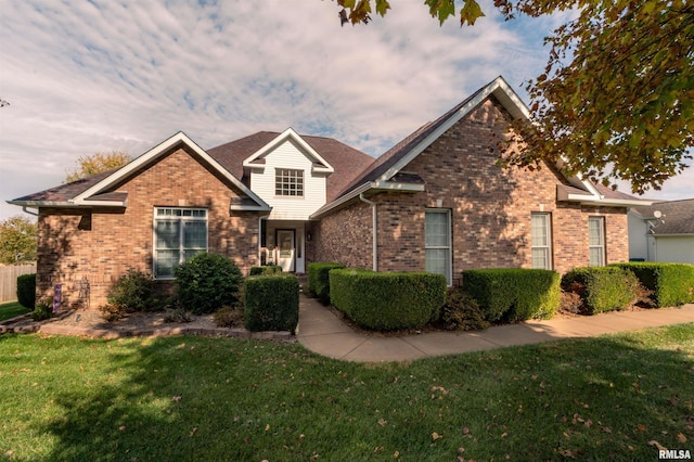 traditional-style house featuring brick siding and a front lawn