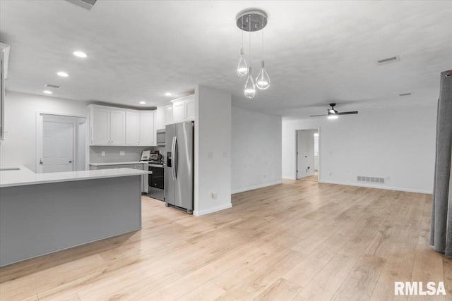 19109 Bluff Rd Unit D, Geneseo, IL 61254 - kitchen featuring stainless steel appliances, light countertops, white cabinetry, open floor plan, and light wood-type flooring
