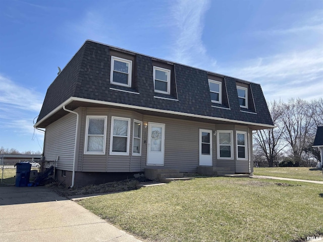 view of front facade with entry steps, a front yard, mansard roof, and roof with shingles