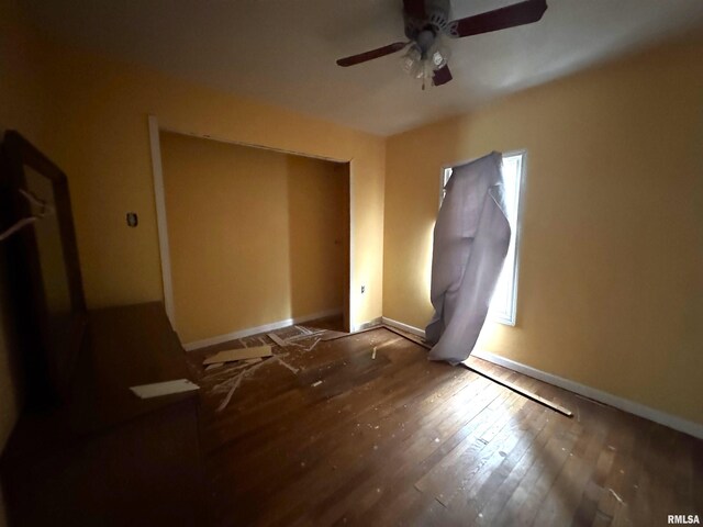 502 E 2nd St, Maquon, IL 61458 - unfurnished bedroom featuring hardwood / wood-style floors, ceiling fan, and baseboards