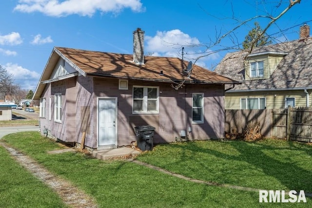 4227 11th St, Rock Island, IL 61201 - rear view of house with a lawn, a chimney, and fence