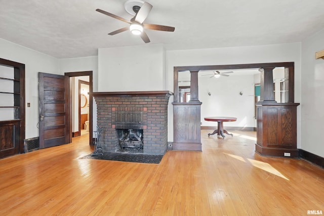2329 Pershing Ave, Davenport, IA 52803 - unfurnished living room featuring a ceiling fan, a fireplace, baseboards, visible vents, and hardwood / wood-style floors