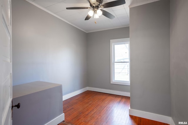 empty room with hardwood / wood-style floors, crown molding, baseboards, and ceiling fan