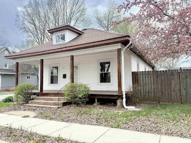 bungalow-style home with a porch and fence