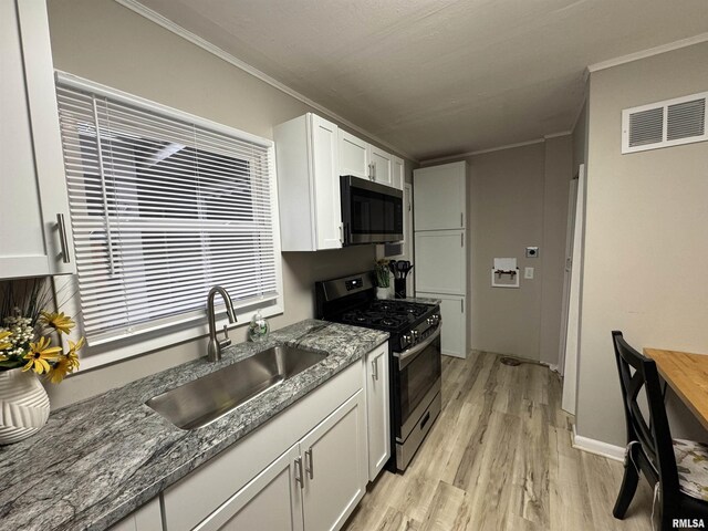kitchen with crown molding, stainless steel appliances, visible vents, and a sink
