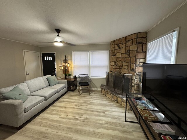 living area featuring a ceiling fan, baseboards, ornamental molding, and wood finished floors
