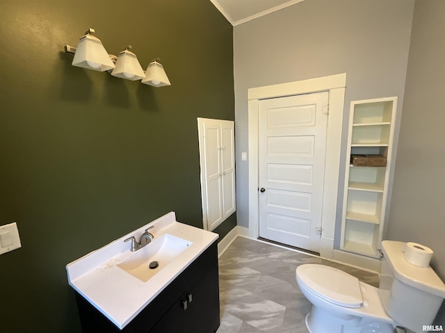 bathroom featuring baseboards, toilet, ornamental molding, and vanity