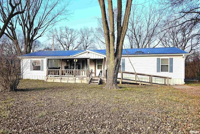 view of front of property featuring covered porch and metal roof