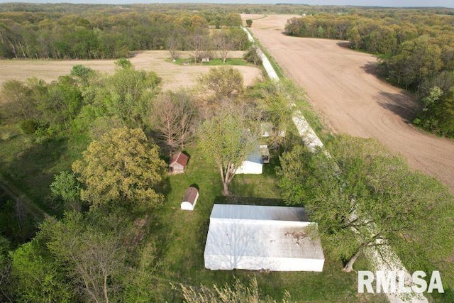 view of property location with a heavily wooded area and rural landscape