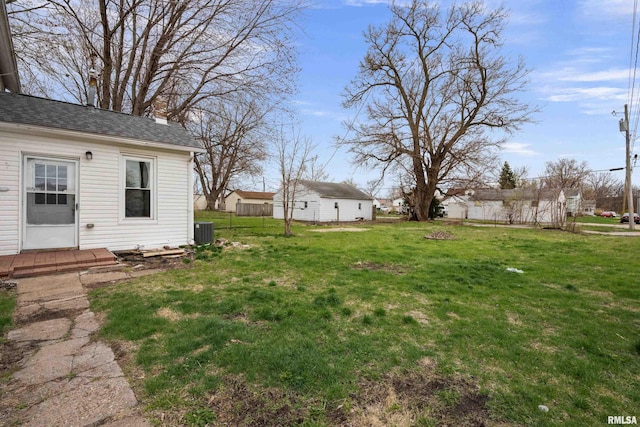 view of yard featuring fence and central air condition unit