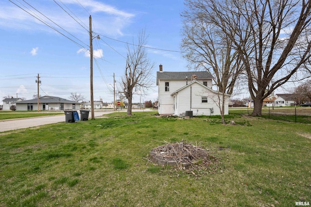 view of yard featuring cooling unit, fence, and an outdoor fire pit