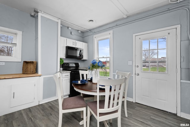 dining space with dark wood-type flooring, visible vents, and baseboards