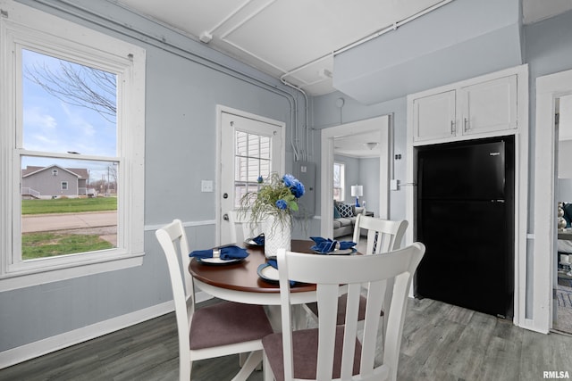 dining area featuring light wood finished floors and baseboards
