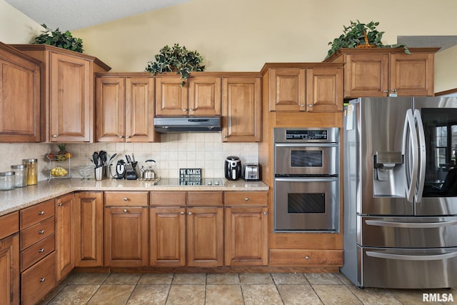 922 W Scott St, Eldridge, IA 52748 - kitchen with brown cabinets, under cabinet range hood, backsplash, and stainless steel appliances