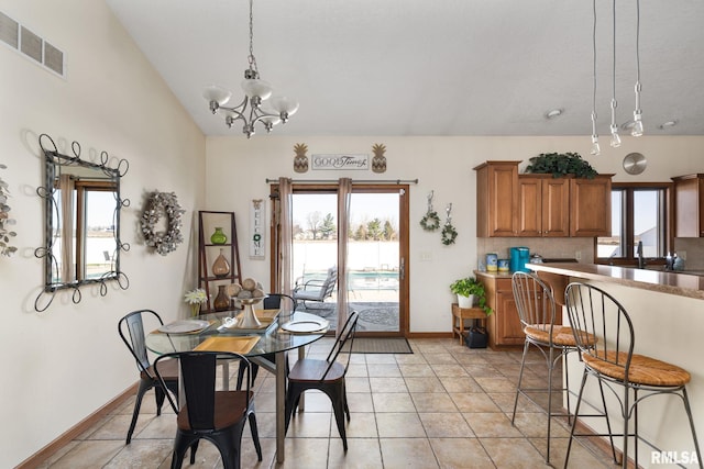 922 W Scott St, Eldridge, IA 52748 - dining room with vaulted ceiling, baseboards, a chandelier, light tile patterned flooring, and visible vents