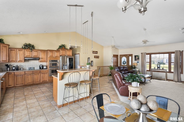 922 W Scott St, Eldridge, IA 52748 - kitchen with appliances with stainless steel finishes, brown cabinets, open floor plan, under cabinet range hood, and ceiling fan with notable chandelier