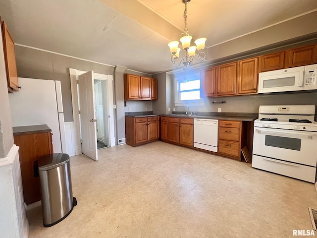 kitchen featuring white appliances, an inviting chandelier, dark countertops, brown cabinets, and light floors