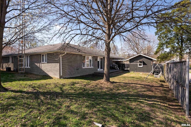 exterior space with a lawn, brick siding, and fence