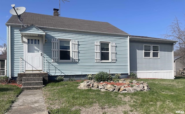 730 3rd St, Buffalo, IA 52728 - rear view of house featuring entry steps, a chimney, and a lawn