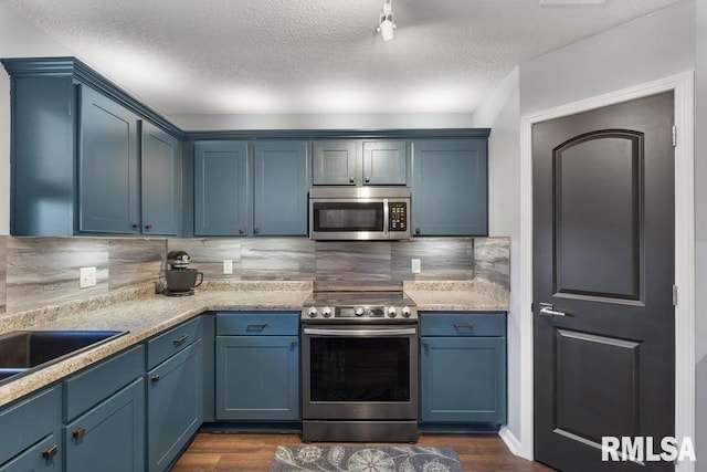 1708 Westport Dr, Davenport, IA 52804 - kitchen with decorative backsplash, blue cabinets, appliances with stainless steel finishes, light countertops, and dark wood-style floors