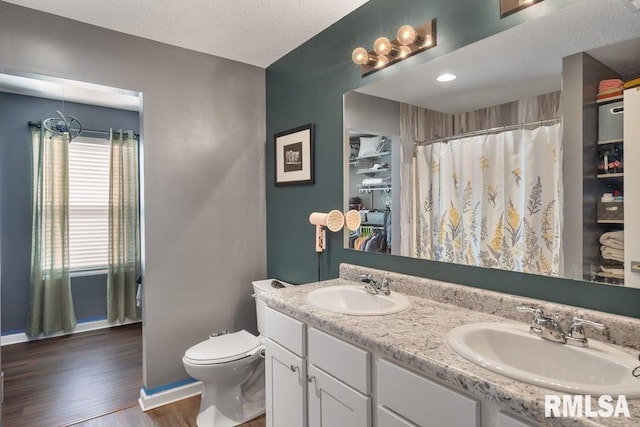1708 Westport Dr, Davenport, IA 52804 - bathroom featuring baseboards, a sink, wood finished floors, and toilet