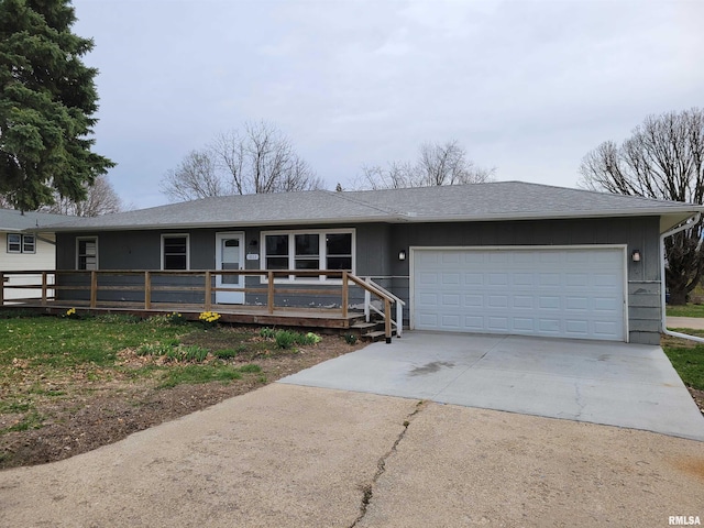 ranch-style home with driveway, an attached garage, and roof with shingles