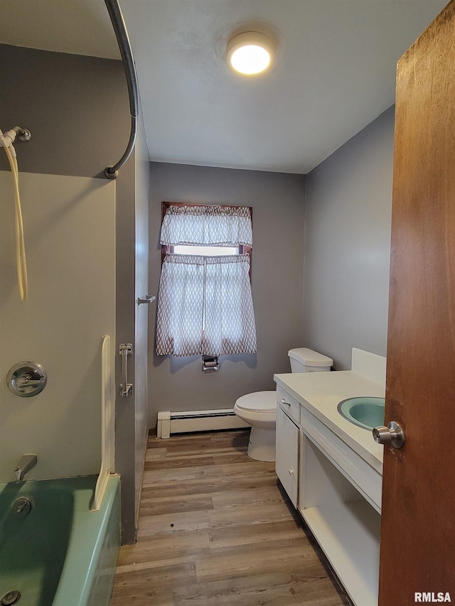 full bath with vanity, toilet, baseboard heating, washtub / shower combination, and wood finished floors