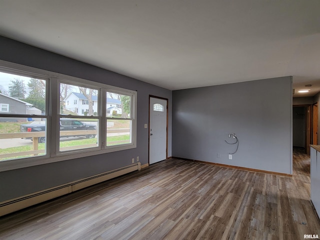 interior space featuring wood finished floors, baseboards, and baseboard heating