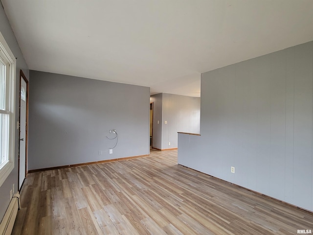 spare room with light wood finished floors and baseboard heating