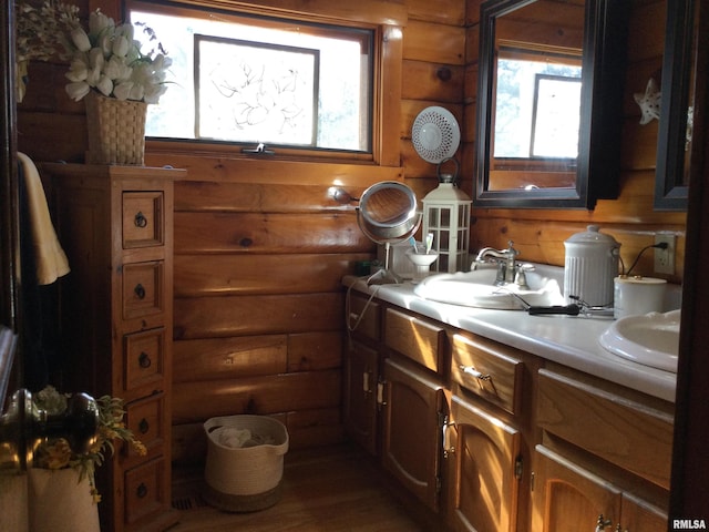 5453 Cherokee Ln, Carbondale, IL 62901 - bathroom with log walls, double vanity, a sink, and wood finished floors