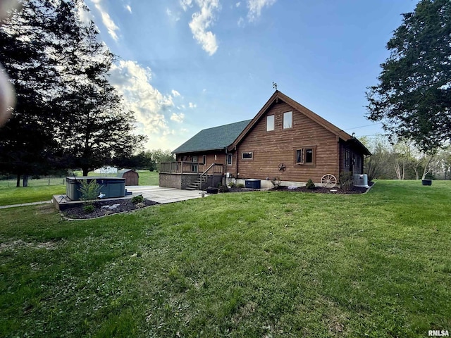 5453 Cherokee Ln, Carbondale, IL 62901 - back of house with a hot tub, a lawn, a patio, central AC unit, and a deck