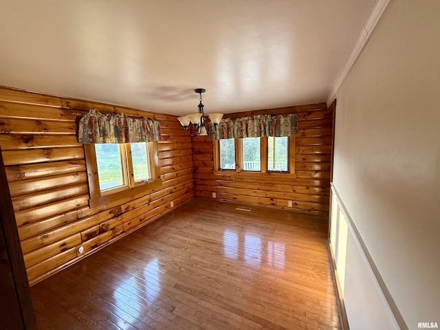 5453 Cherokee Ln, Carbondale, IL 62901 - unfurnished room with crown molding, log walls, an inviting chandelier, and light wood-style floors