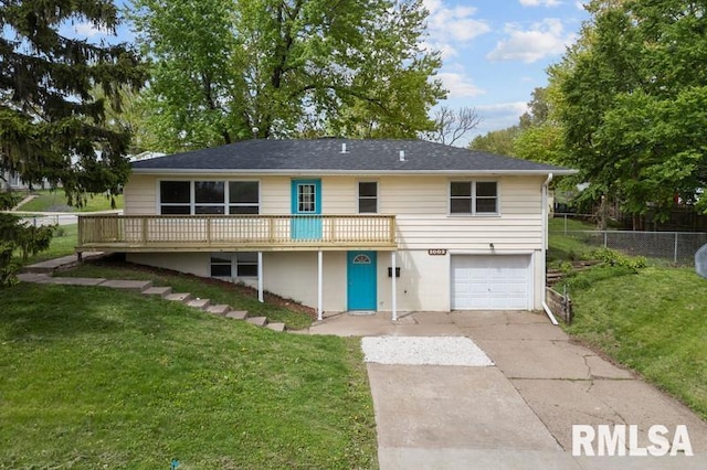 rear view of property with a yard, concrete driveway, a garage, and a deck