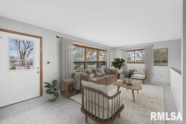 living area featuring light carpet and baseboards