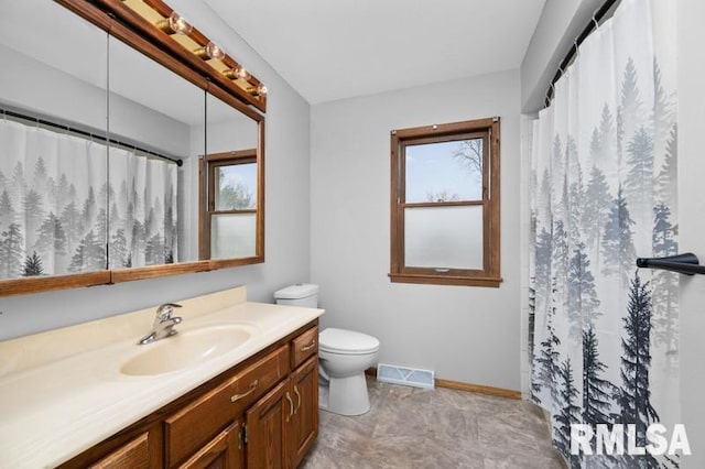 bathroom with toilet, a healthy amount of sunlight, vanity, and visible vents