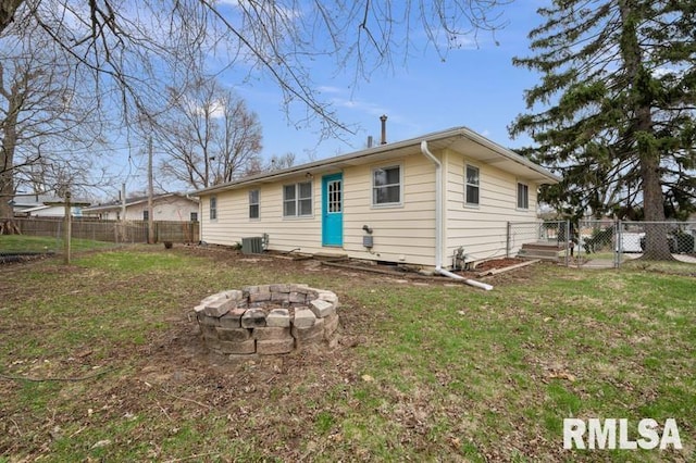 back of house with a fenced backyard, an outdoor fire pit, a gate, and a yard