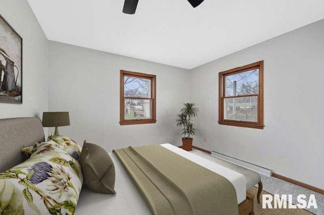 bedroom featuring carpet flooring, multiple windows, baseboards, and a baseboard radiator
