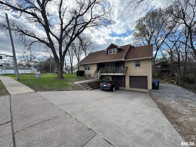 view of side of home with stairway, driveway, brick siding, a garage, and a lawn