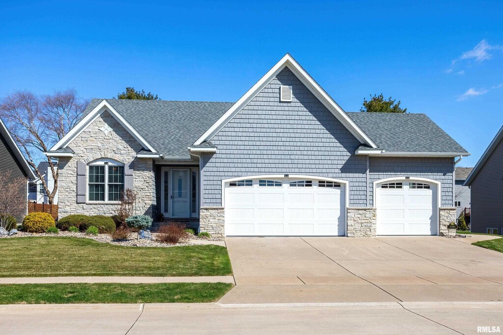 5106 N Richmond Cir, Bettendorf, IA 52722 - craftsman-style home featuring stone siding, an attached garage, concrete driveway, and a front lawn