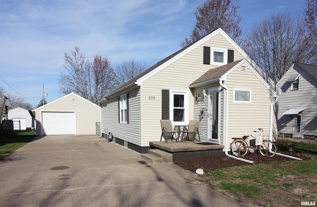 view of front of home with driveway, an outbuilding, and a detached garage