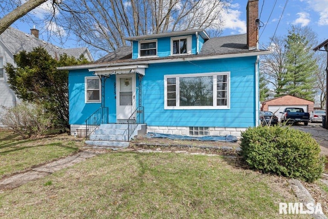 bungalow featuring a detached garage, a front yard, a chimney, and entry steps