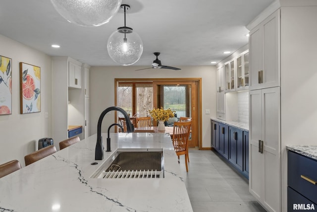 kitchen with blue cabinets, open shelves, decorative backsplash, and recessed lighting