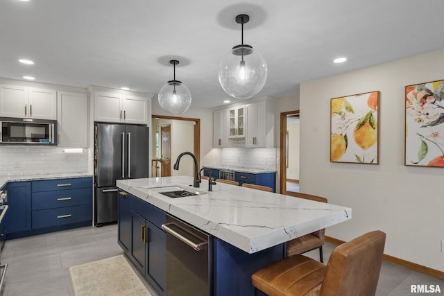 kitchen with appliances with stainless steel finishes, a sink, white cabinets, backsplash, and recessed lighting