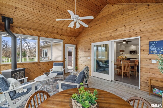 sunroom with a wood stove and vaulted ceiling