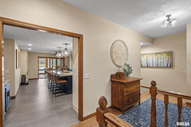 hallway with baseboards and a textured ceiling