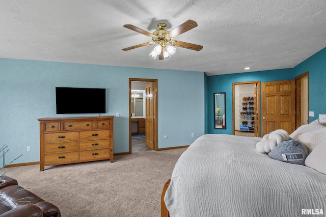 bedroom featuring light colored carpet, baseboards, a ceiling fan, connected bathroom, and a textured ceiling
