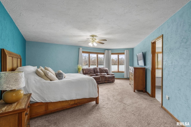 bedroom with a textured ceiling, light carpet, ceiling fan, and a textured wall