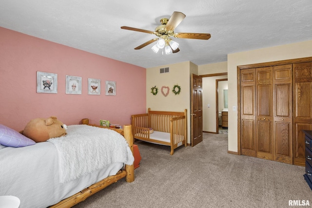 bedroom featuring light colored carpet, a closet, and ceiling fan