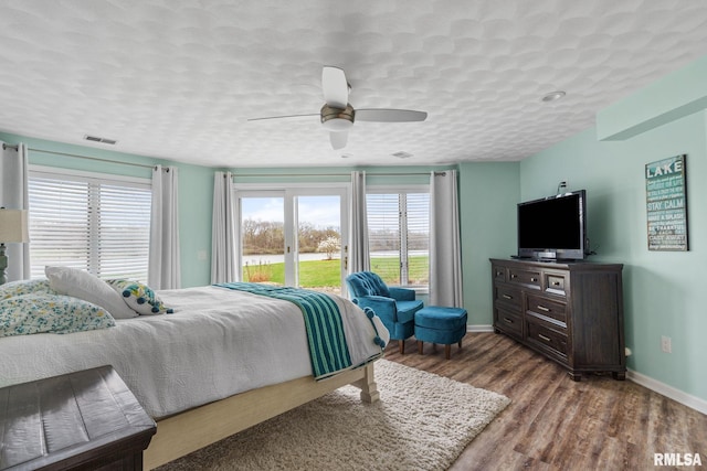 bedroom featuring wood finished floors, ceiling fan, baseboards, and a textured ceiling