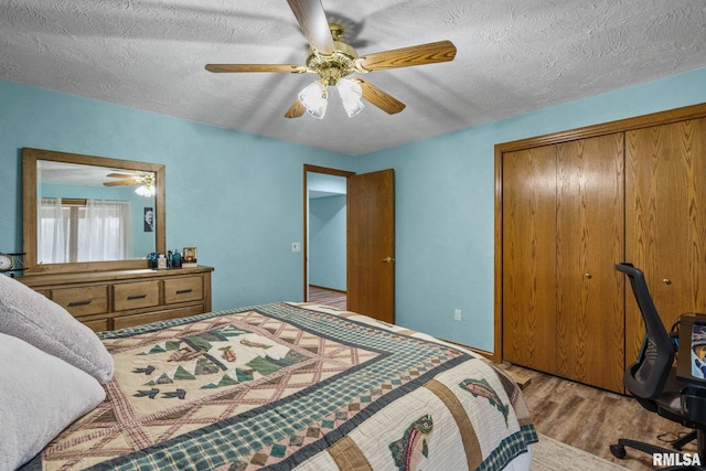 bedroom featuring wood finished floors, a textured ceiling, and a ceiling fan